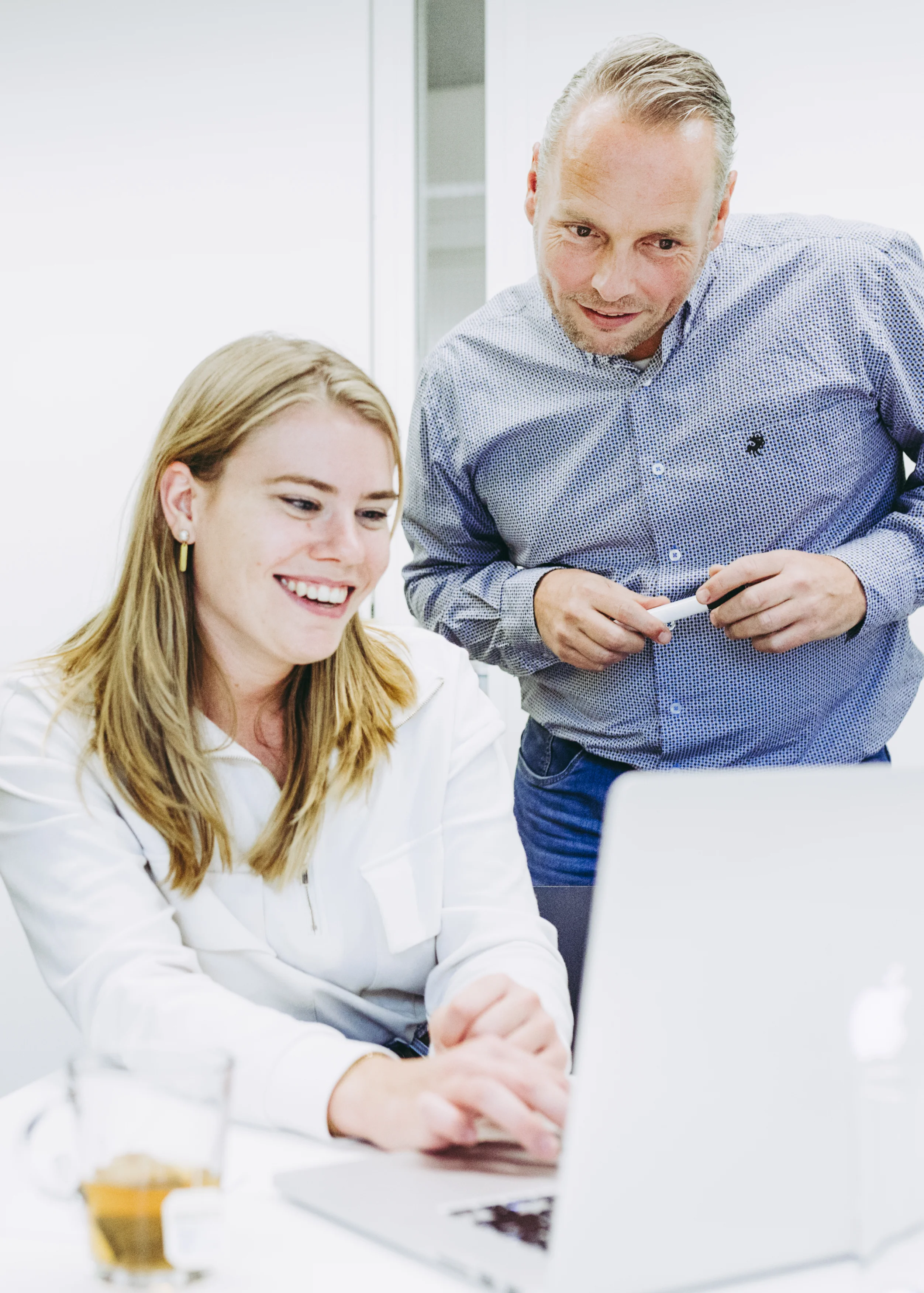 Collega's werkend achter een laptop